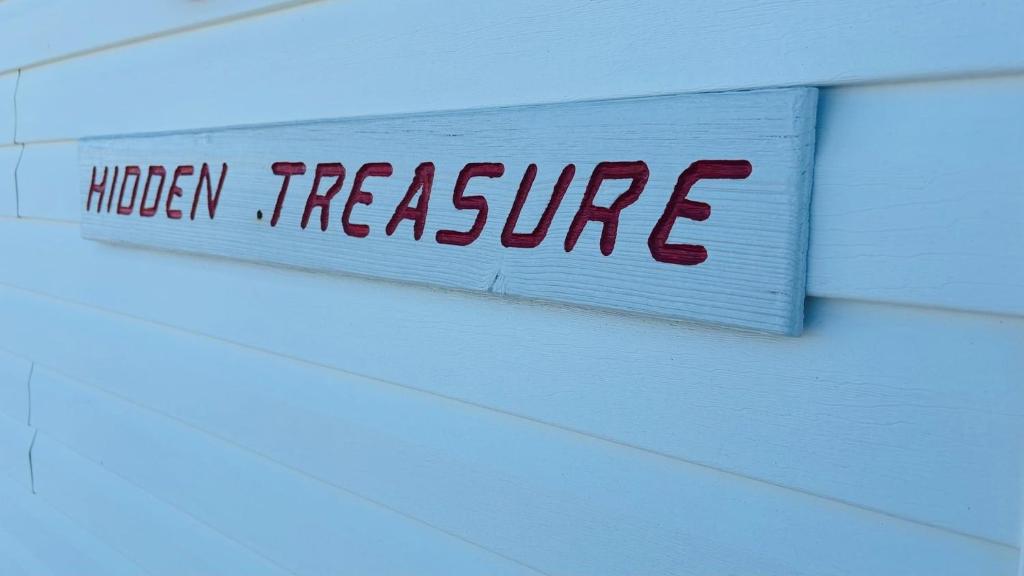 a sign that reads hidden treasure hanging on a wall at Hidden Treasure in Holden Beach