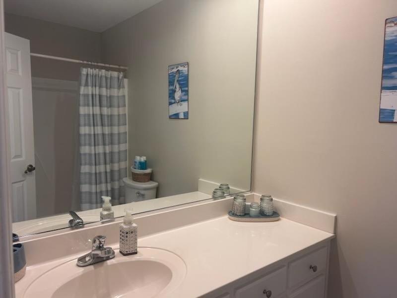 a bathroom with a sink and a large mirror at 218 Brunswick home in Holden Beach