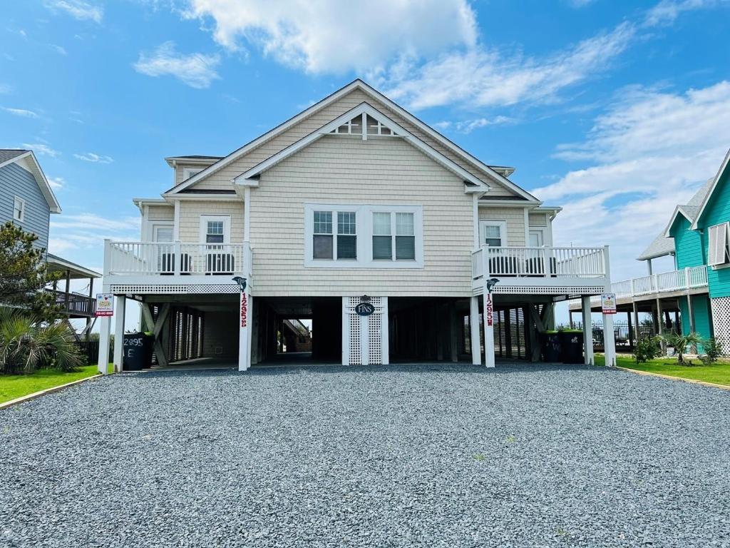 a large house with a balcony and a driveway at Avalon West-Duplex in Holden Beach