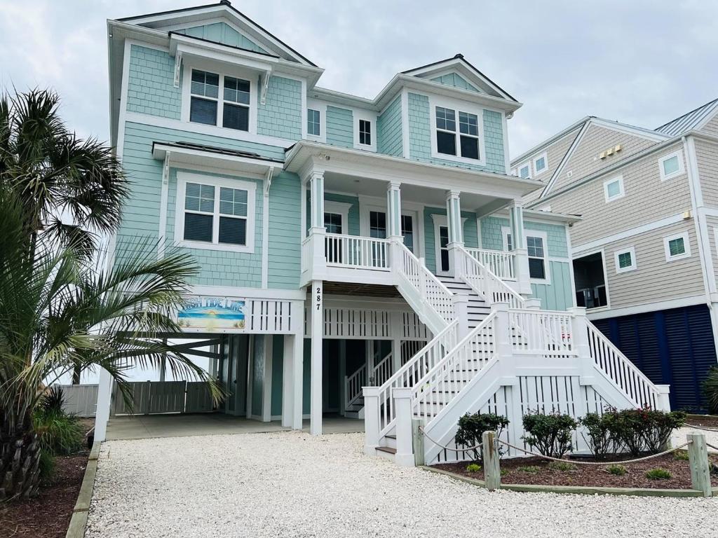 a blue house with white stairs in front of it at 287 OBW home in Holden Beach