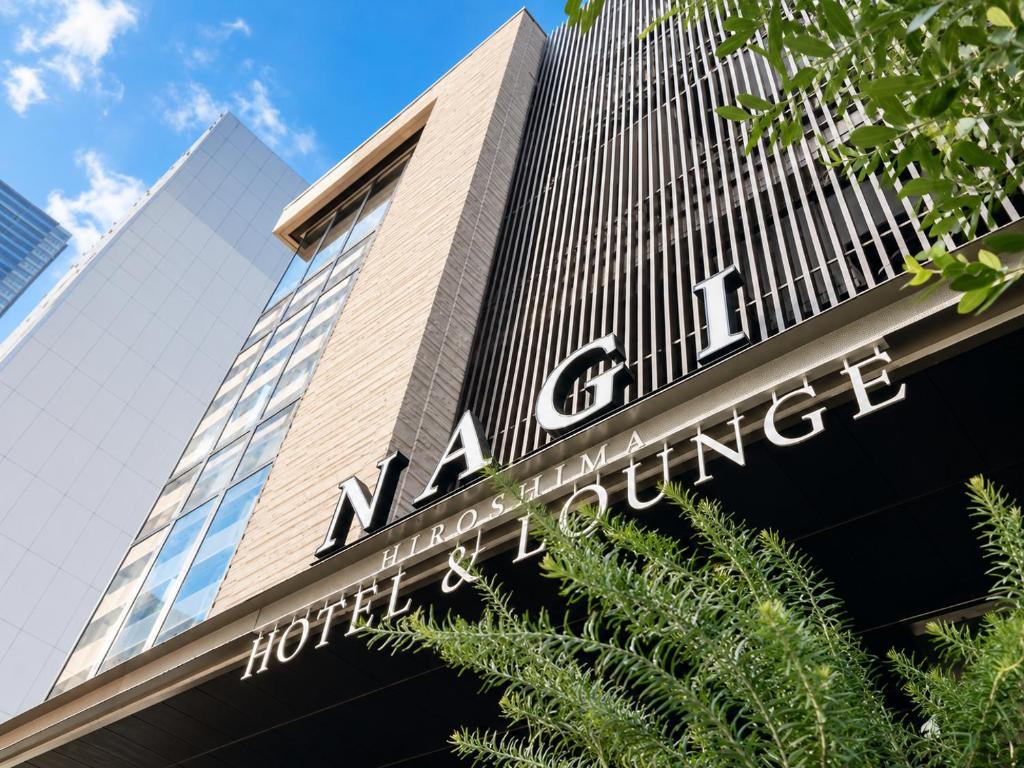 a building with a sign on the side of it at NAGI Hiroshima Hotel and Lounge in Hiroshima