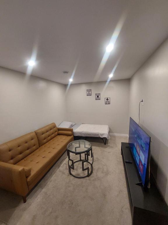 a living room with a couch and a table at Cozy Private Suite with Parking near restaurants in Regina