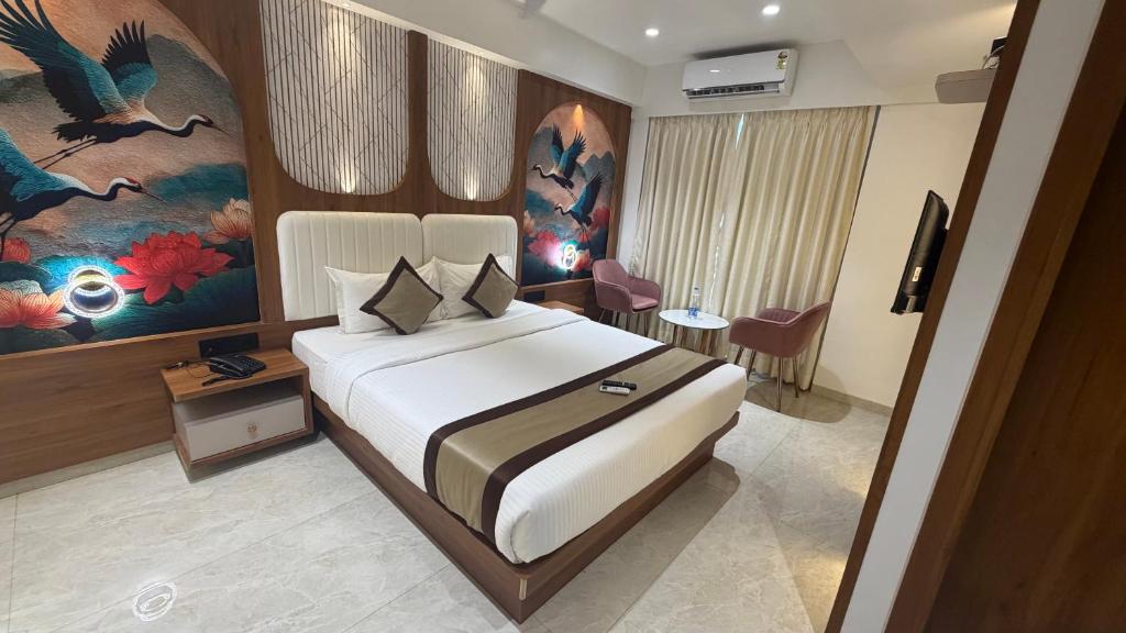 a bedroom with a large bed in a room at Hotel Shree Krishna Paradise Dombivali in Dombivli
