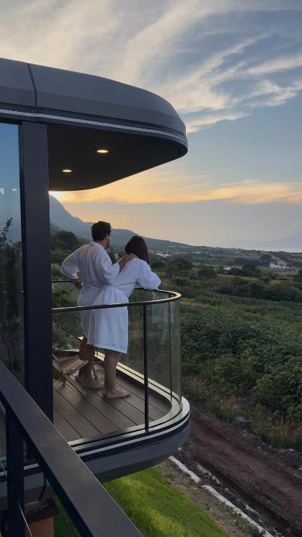 two people standing on a balcony of a house at Lua Mazamitla in San Luis Soyatlán