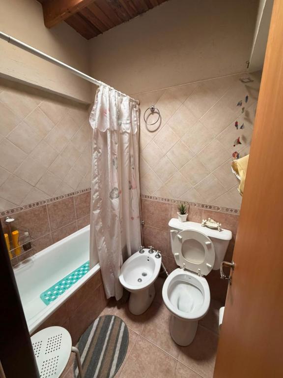 a bathroom with a toilet and a sink and a tub at TRAPICHE SUITES HABITACIONEs in Godoy Cruz