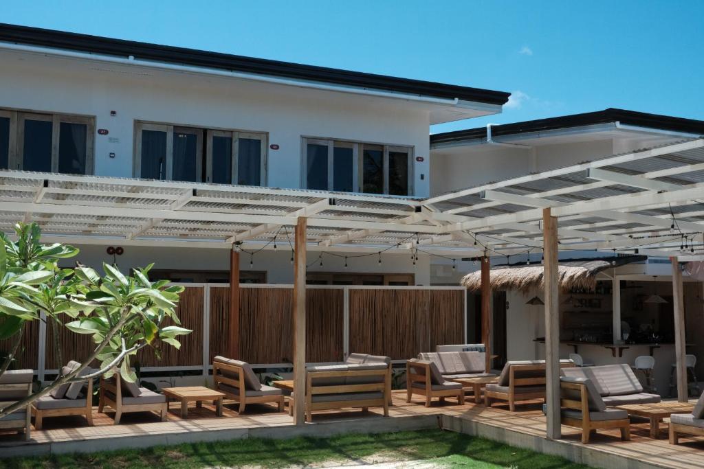 a patio with chairs and umbrellas in front of a building at Soluna Siquijor Boutique Resort in San Juan