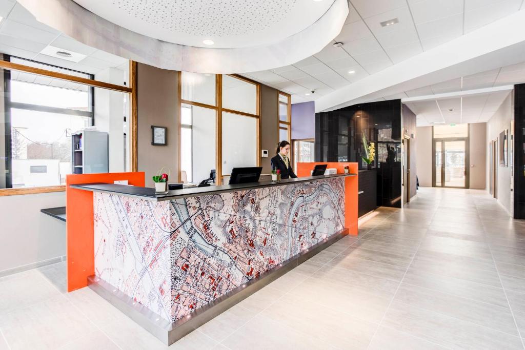 a woman sitting at a counter in an office at Hotel ParkSaône in Lyon