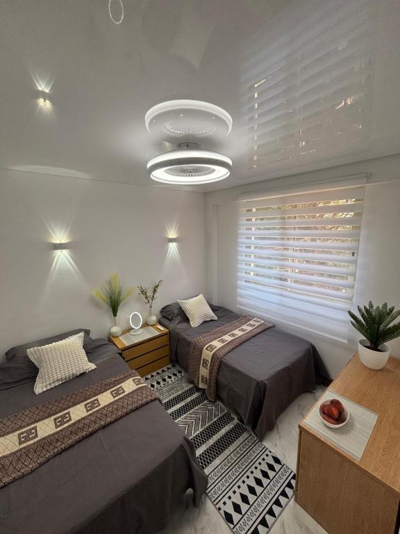a bedroom with two beds and a large window at Salou Guesthouse in Salou