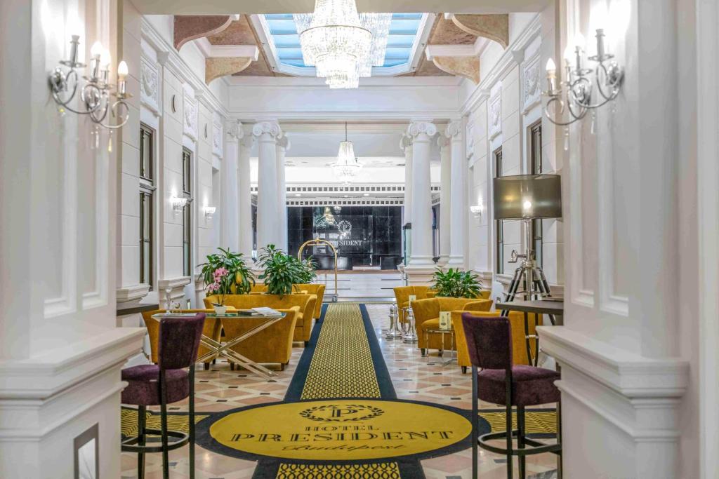 a lobby with chairs and a table in a building at Hotel President Budapest, Affiliated by Meliá in Budapest