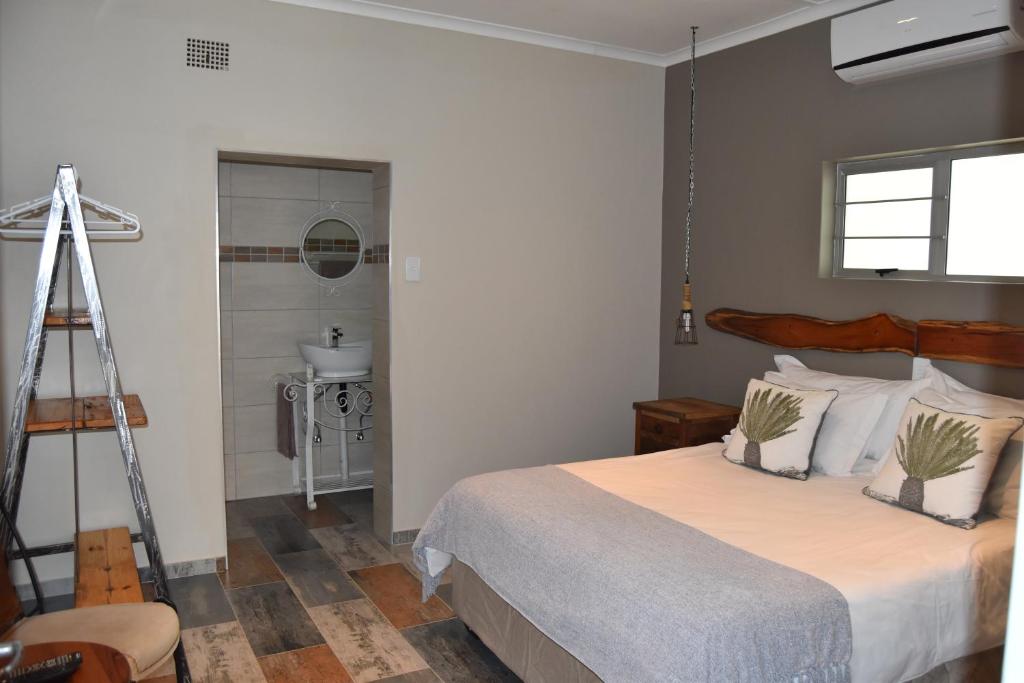 una camera con un grande letto e un bagno di Quiver Inn Guesthouse a Keetmanshoop