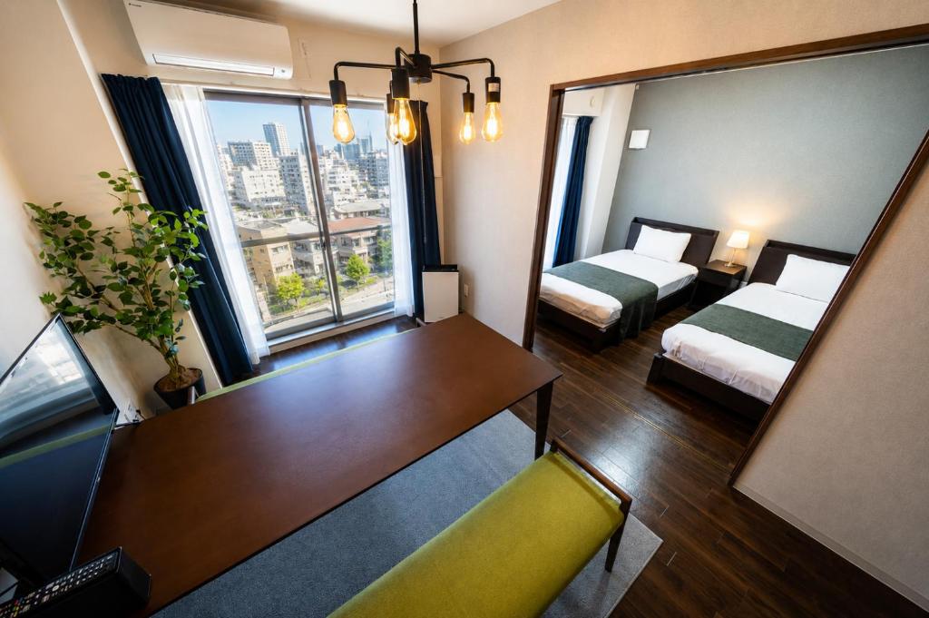 a room with two beds and a table and a mirror at Hotel Piacere NAMBA in Osaka