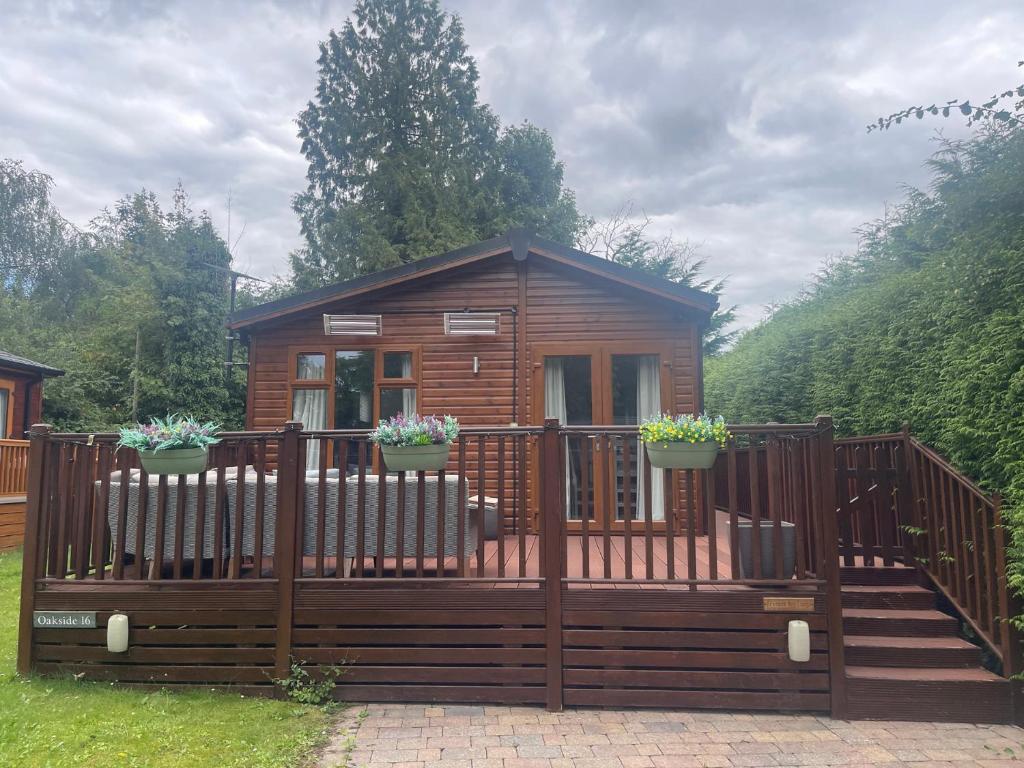 a small wooden cabin with a wooden fence at Bowness Bay Lodge in Windermere