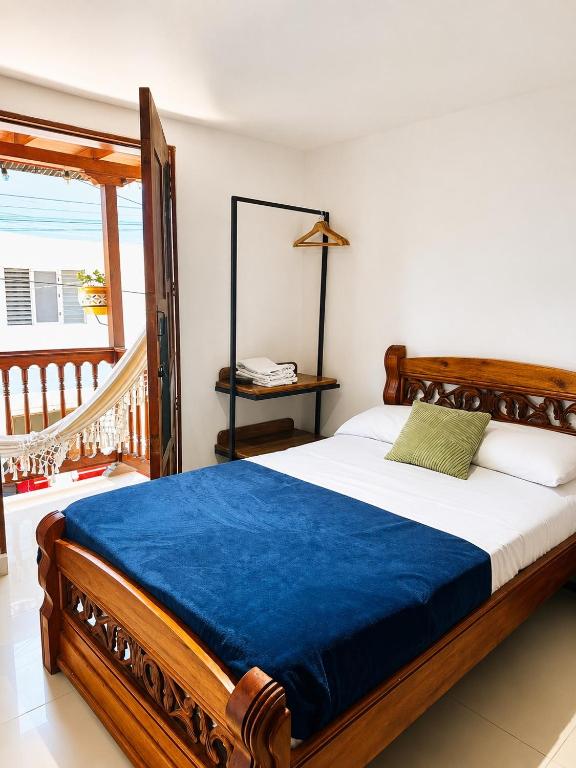 a bedroom with a wooden bed with a blue blanket at Hotel Jardin de Rosas in Jardin