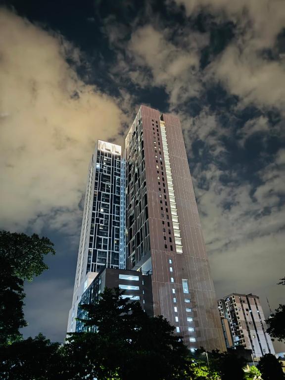 a tall building with lights on in a city at Chambers Elite Suites KLCC in Kuala Lumpur