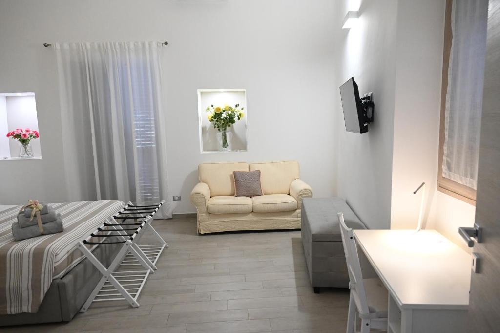 a white living room with a couch and a chair at Maris Terra in Brindisi