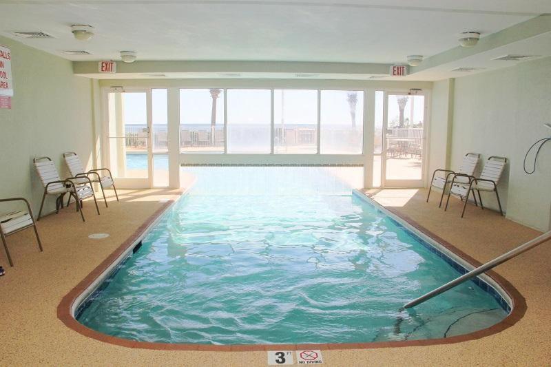 a large swimming pool in a building with chairs at TradeWinds 102 in Romar Beach