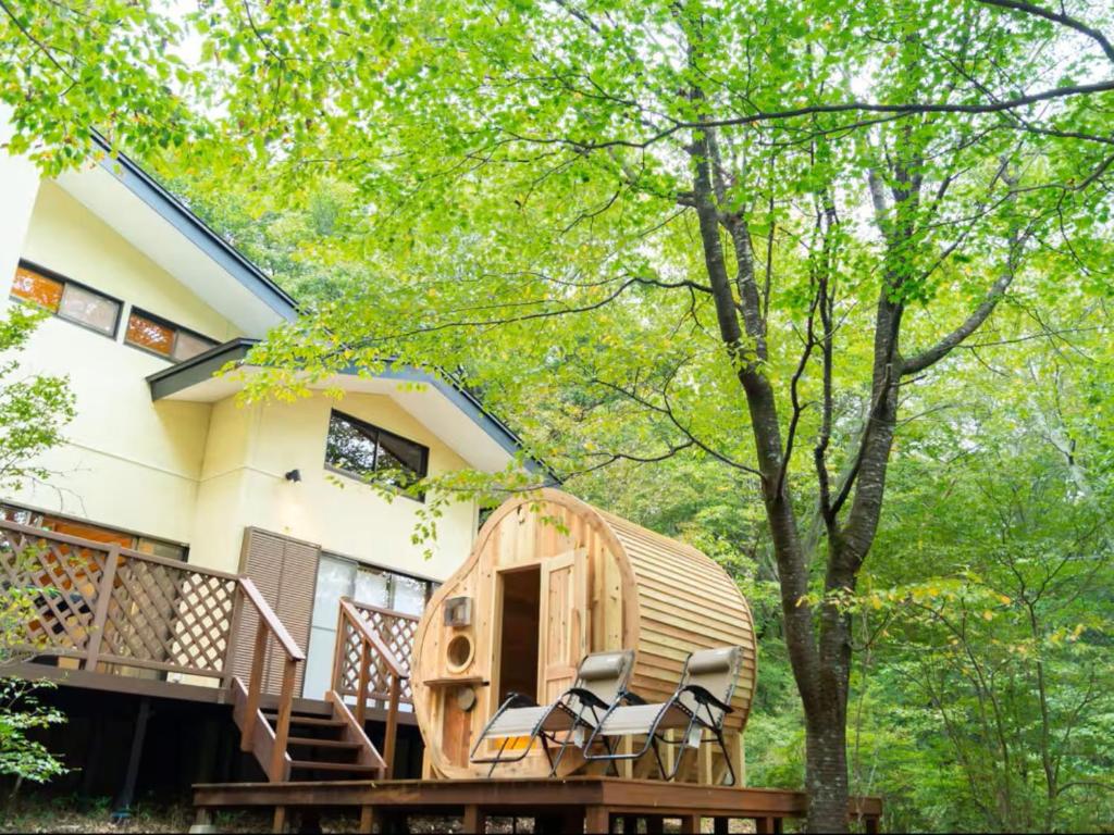 a tree house with chairs in front of a house at rinne 2nd living Sauna Villa Nasu in Nasu