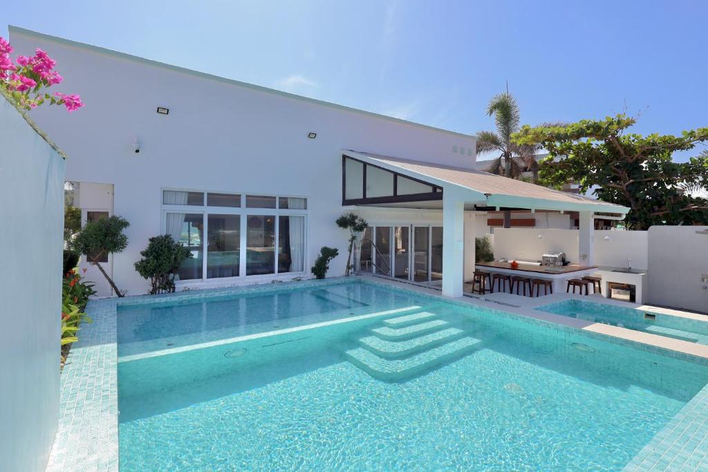 a swimming pool in front of a house at Alesea Baroro, La Union, Private Modern Villa with Pool, Jacuzzi, Beachfront View in Balio