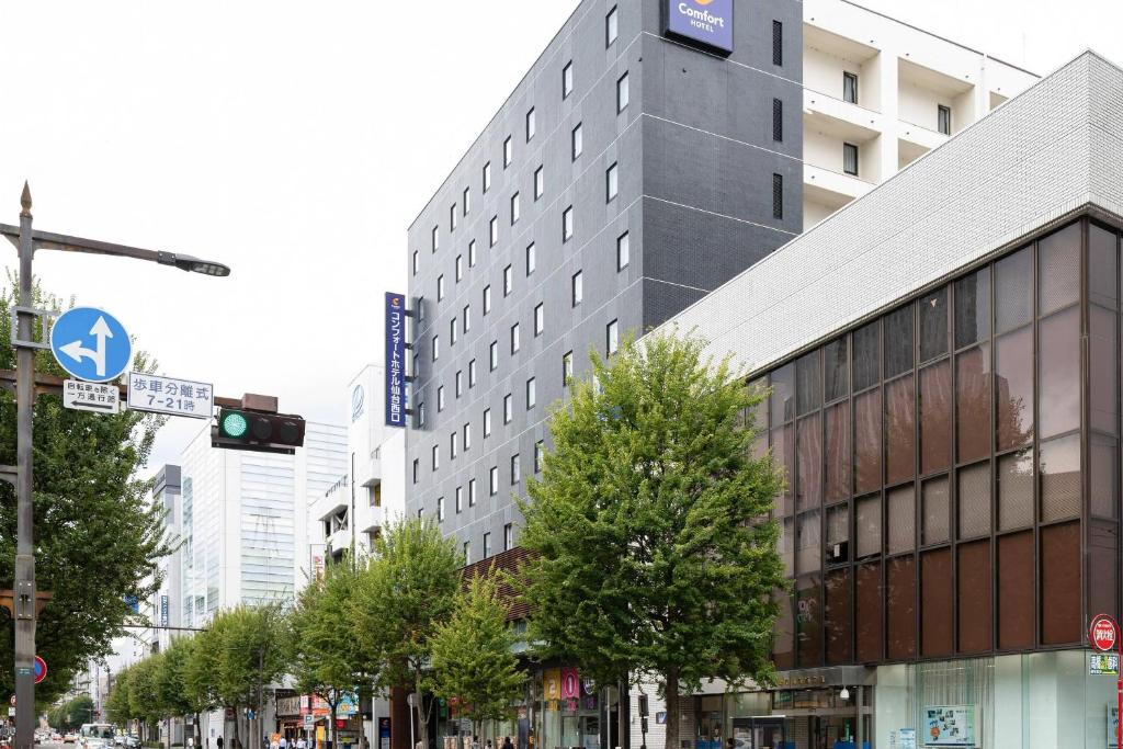 a tall building on a city street with a traffic light at Comfort Hotel Sendai West in Sendai