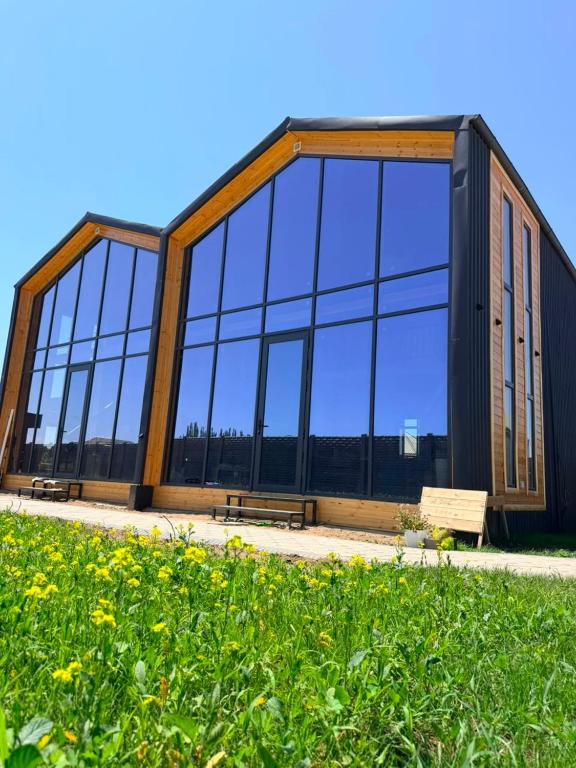a building with large glass windows and a bench at Barnhouse Allan in Koshkolʼ