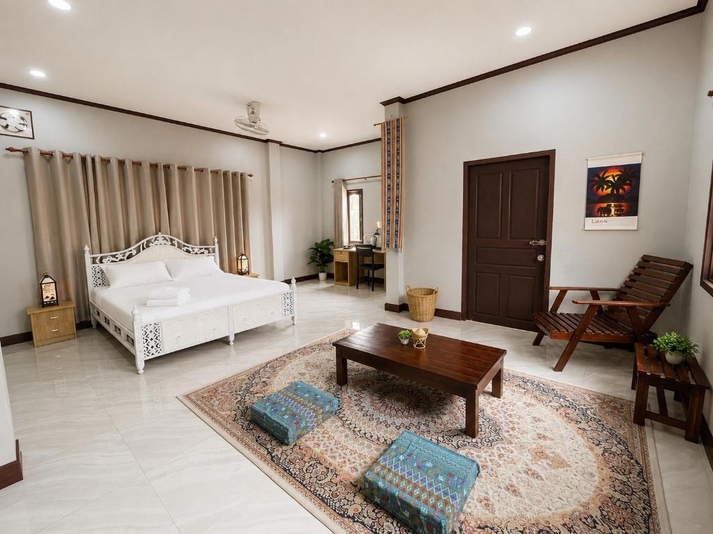 a bedroom with a bed and a coffee table at Ban Loom Guesthouse & Weaving Workshop in Luang Prabang