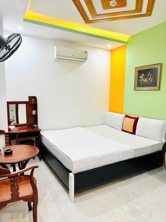 a room with a bed and a desk and a table at Khách sạn Tuyết Minh in Xã Thang Tam