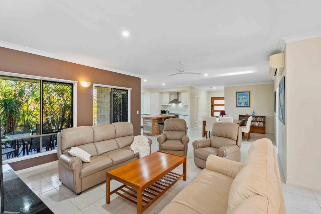 a living room with a couch and a table at The Seahaven - Modern 5 Bedroom Family Home Close to Beach in Pialba