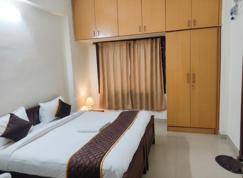 a bedroom with a large bed and a window at Starlighthotels OMR Thoraipakkam Chennai in Chennai