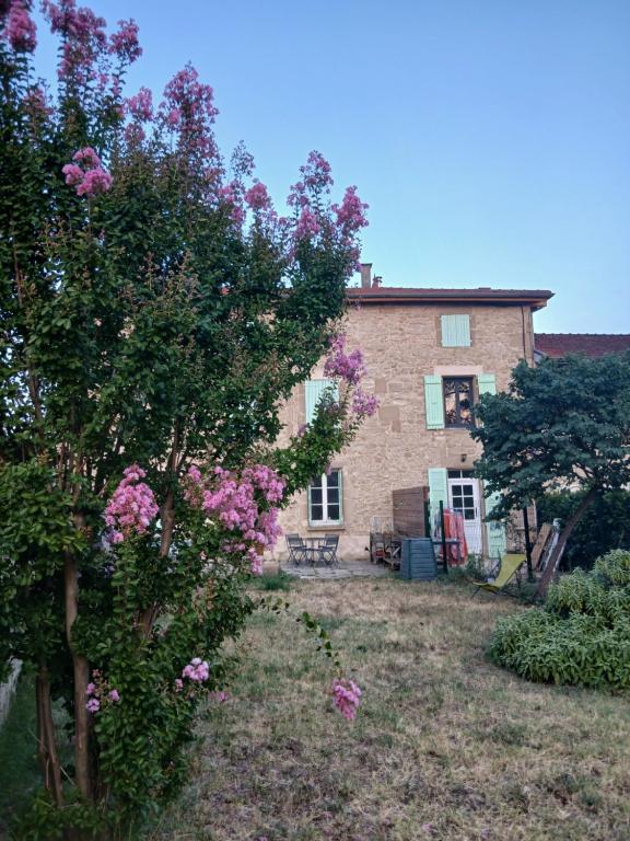 a house with trees and flowers in front of it at Chez Cathy in Saint-Donat-sur-lʼHerbasse