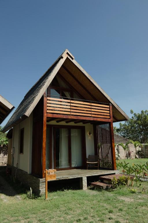a small house with a thatched roof at Mango Garden Villas in Sekongkang Bawa
