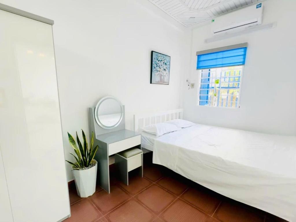 a bedroom with two beds and a mirror at Mộc House in Dong Hoi
