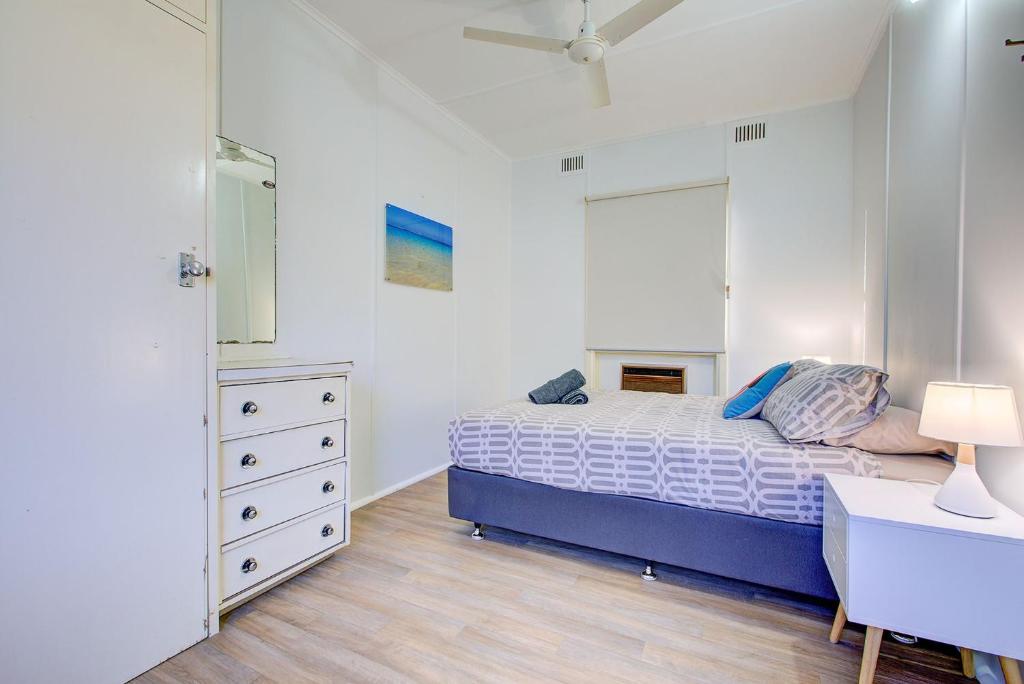 a bedroom with a bed and a dresser in it at Ruby in Exmouth