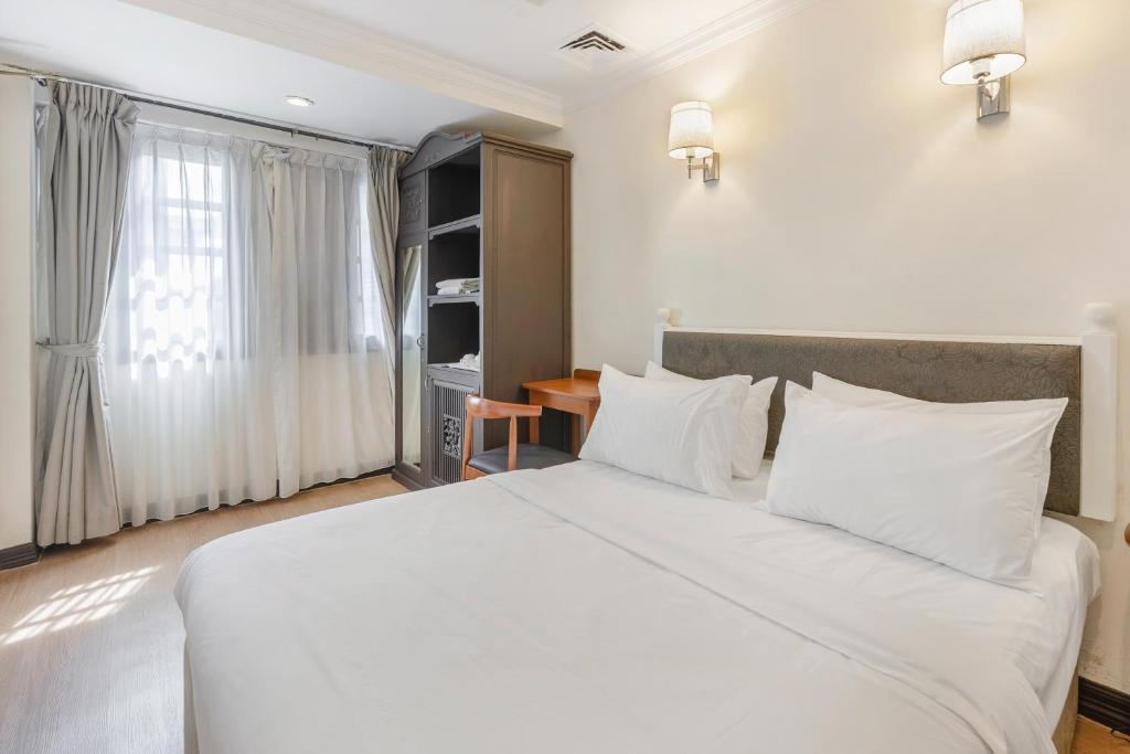 a bedroom with a large white bed and a desk at iNN at Temple St by Q Loft Newly Renovated in Singapore