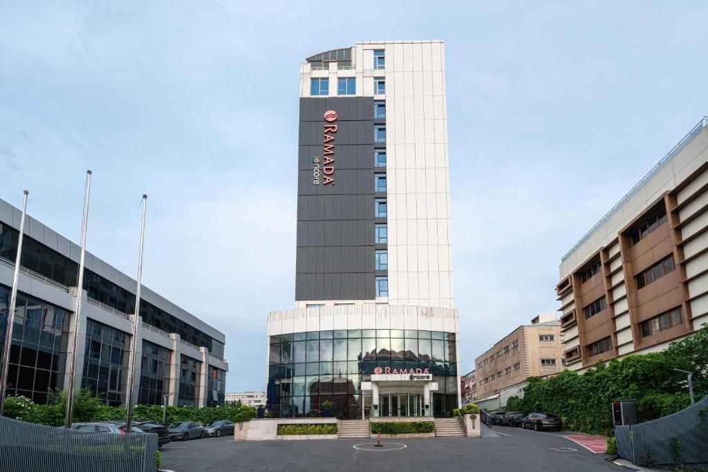 a tall building with a sign on top of it at Ramada Encore Istanbul Bayrampasa in Istanbul