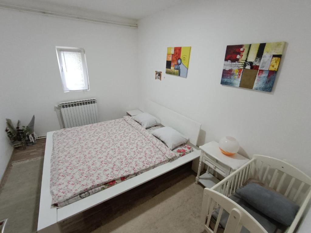 a white bedroom with a bed and a chair at Mountain Relax Vlašić in Vlasic