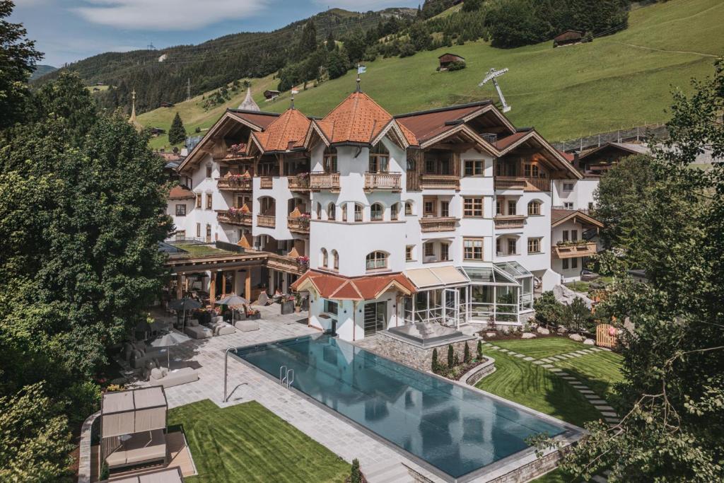 an aerial view of a mansion with a swimming pool at Hotel Gaspingerhof in Gerlos