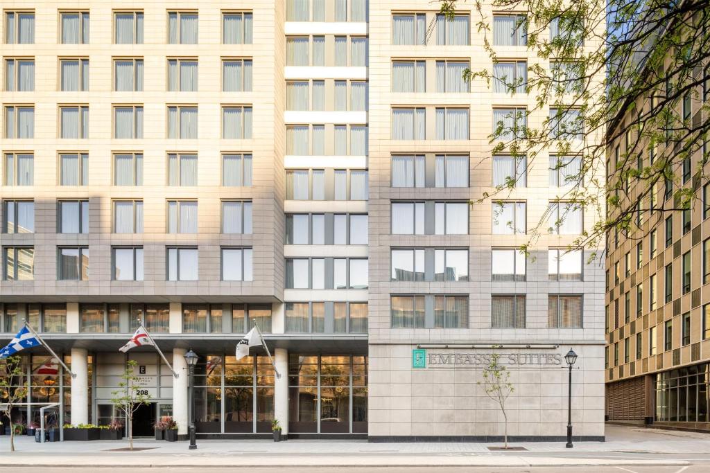 an apartment building with a large building at Embassy Suites by Hilton - Montreal in Montreal