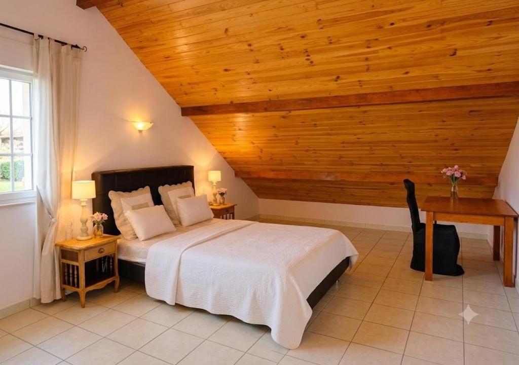 a bedroom with a large bed with a wooden ceiling at Le Rocher des Ducs, Chambres d'hôtes, parking privé, abris motos in Le Glaizil