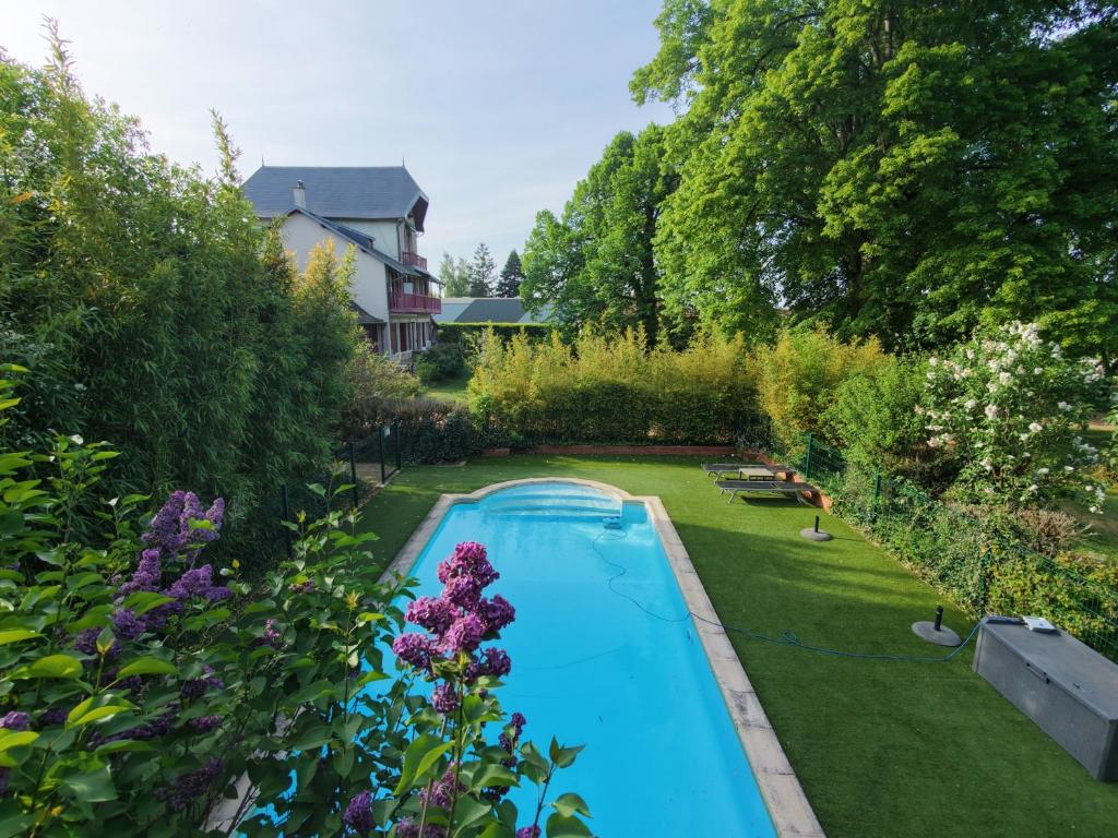 an overhead view of a swimming pool in a garden at Chambres de charme avec piscine - Le Monde de Charlie - Proche Vichy in Vichy
