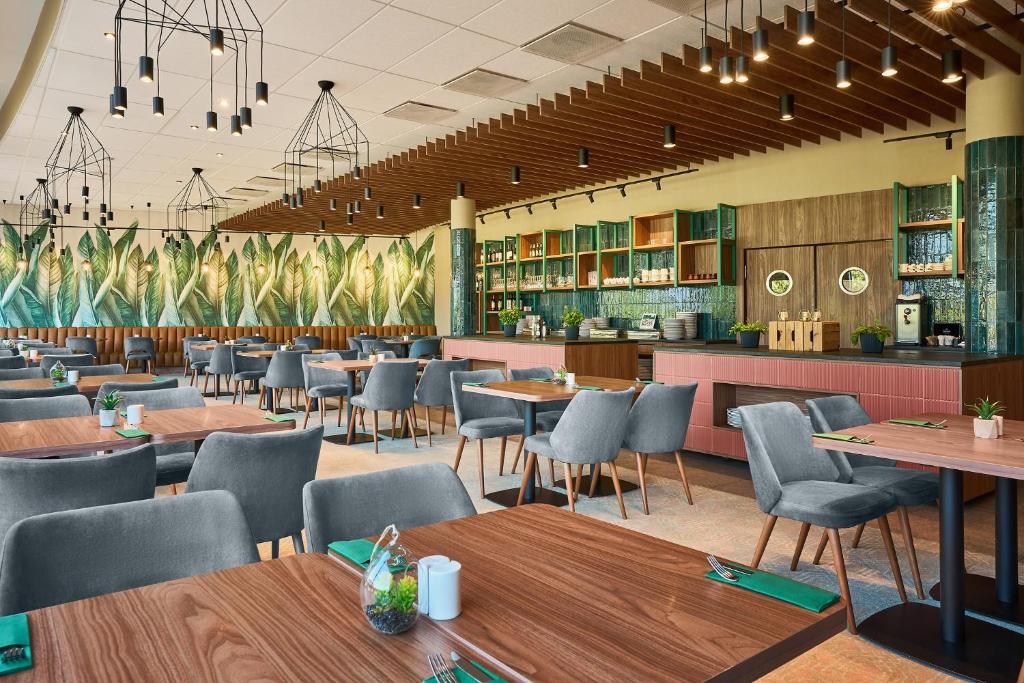 a restaurant with tables and chairs and a bar at Hotel Victor Pruszków DeSilva in Pruszków