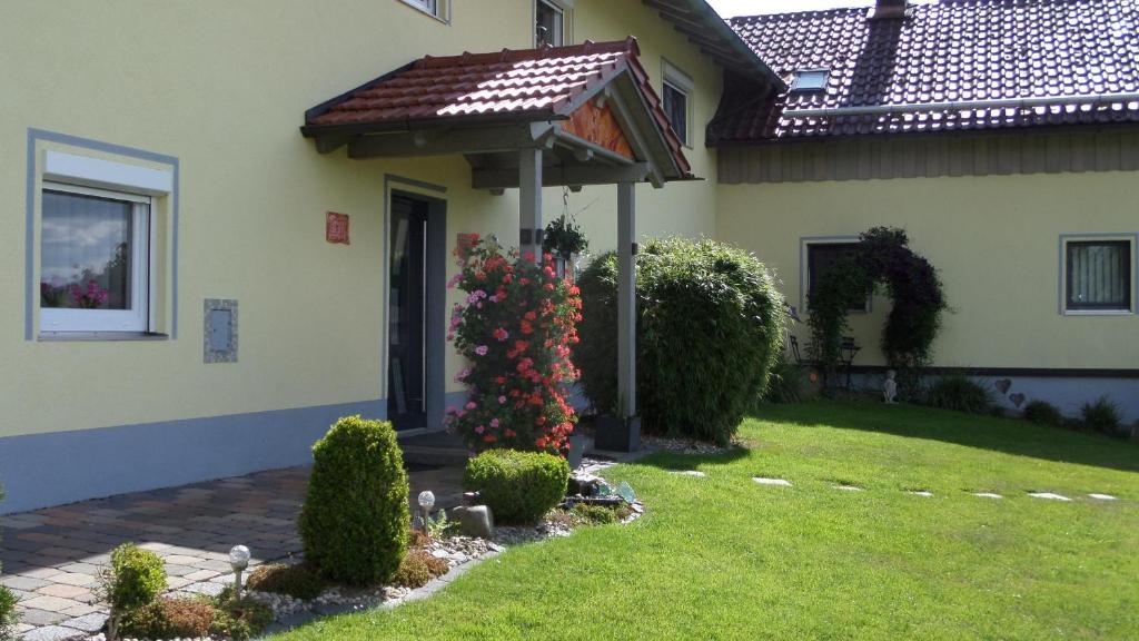 a house with a gazebo and flowers in the yard at FW & FH Lüsselfeld in Zwiesel