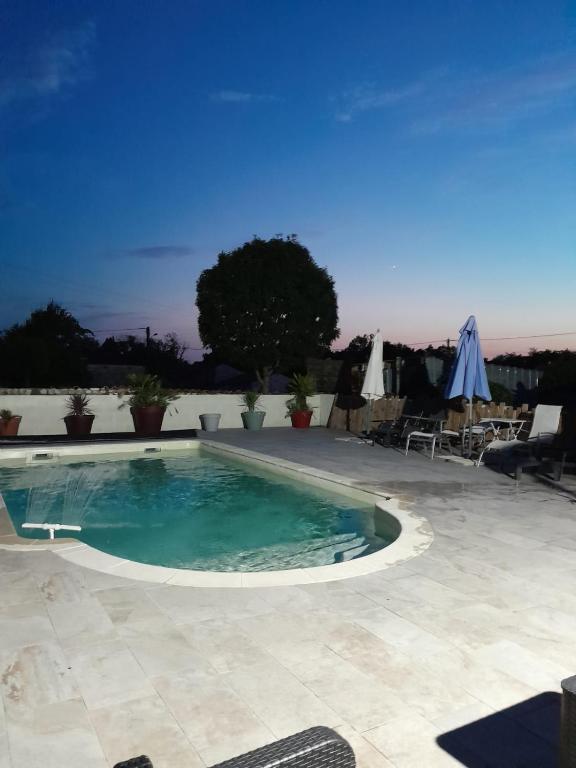 a swimming pool in the middle of a patio at Les Lilas in Saint-Savinien