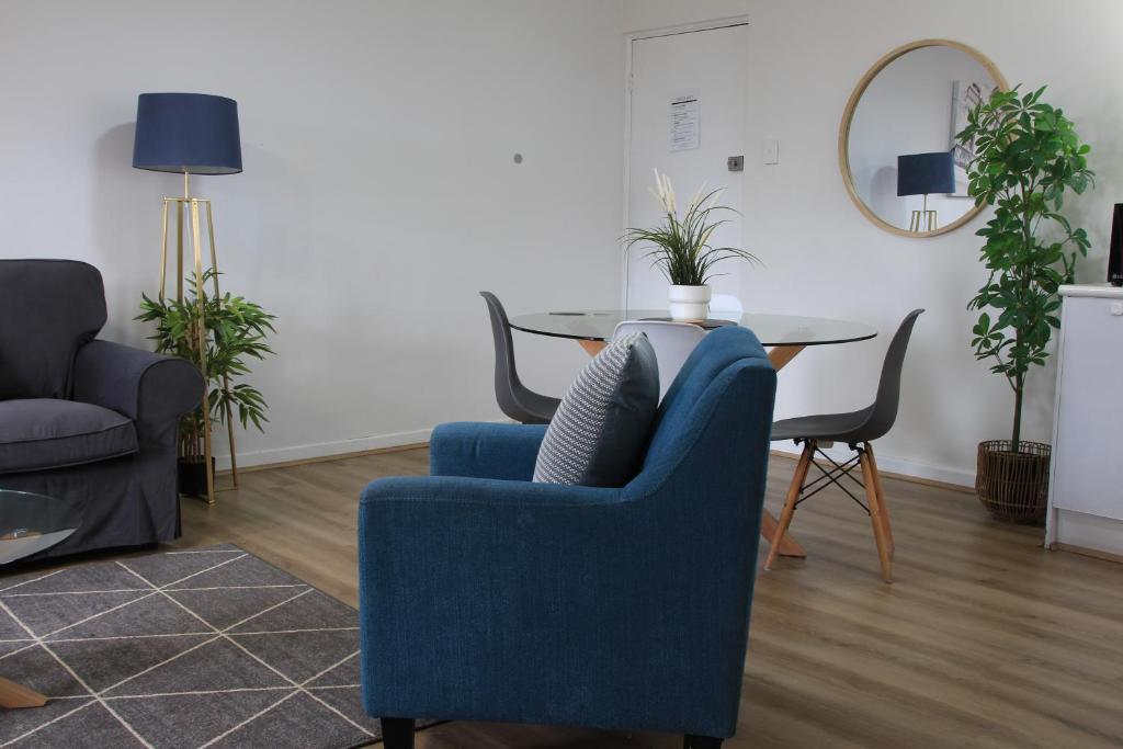 a living room with a blue chair and a table at Apartment 8 Burswood in Perth