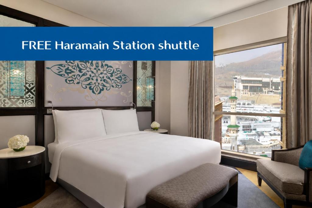 a hotel room with a white bed and a window at Rotana Jabal Omar Makkah in Mecca
