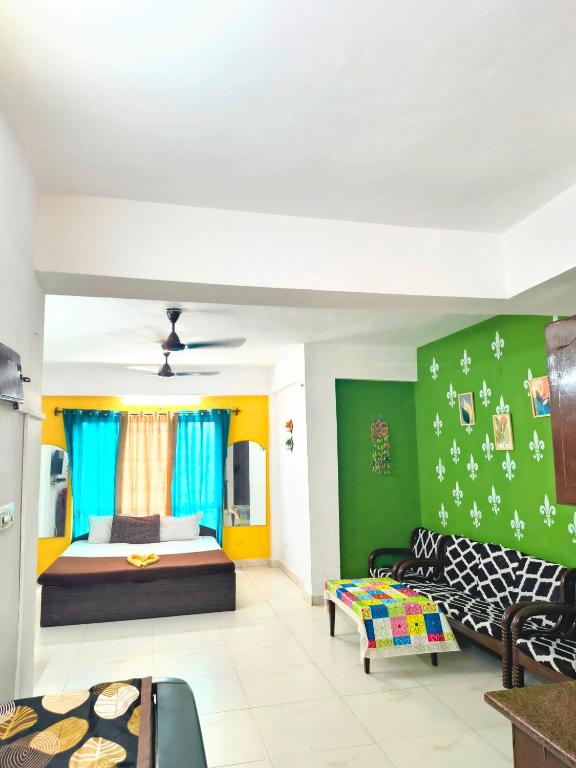 a living room with a bed and a couch at Elite Calangute Beach Holiday Apartments With Pool in Calangute