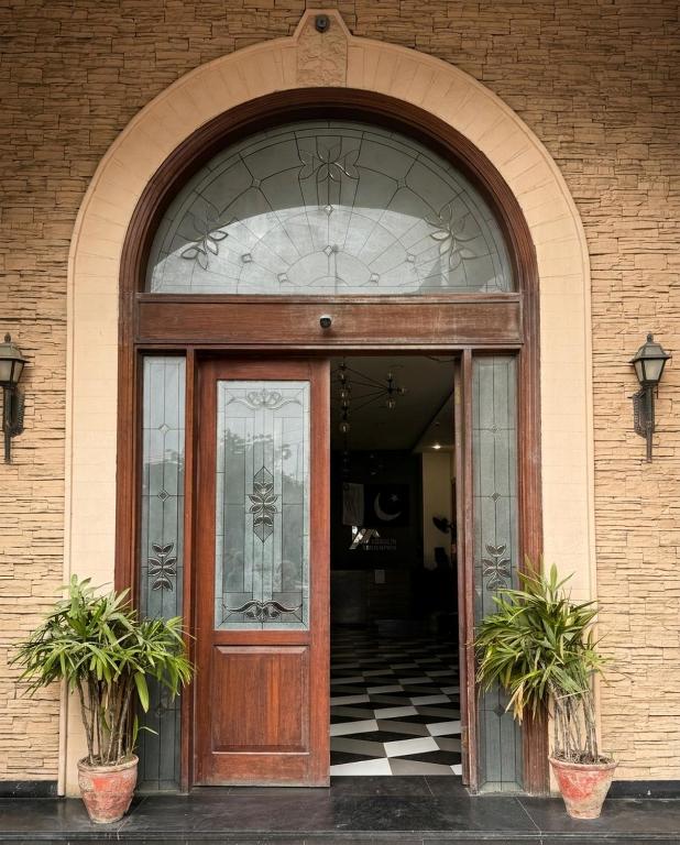 an entrance to a building with a wooden door at Hamsun Apart Hotel Clifton in Karachi