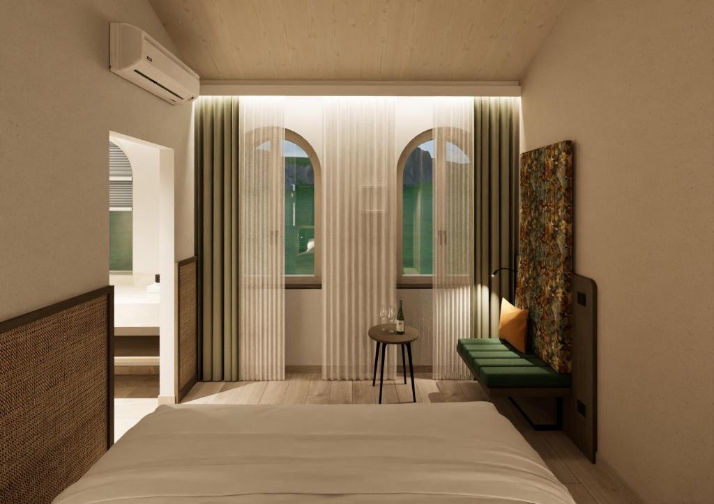 a bedroom with a bed and a chair and a window at Terra Saar, Weinresort & Spa in Saarburg
