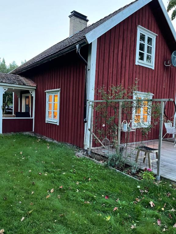a red house with a yard in front of it at Mysigt torp Cozy Cottage in Tranås