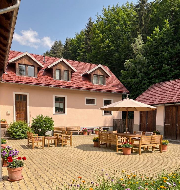 a patio with wooden benches and a building at Krásná pod Lysou horou in Krásná