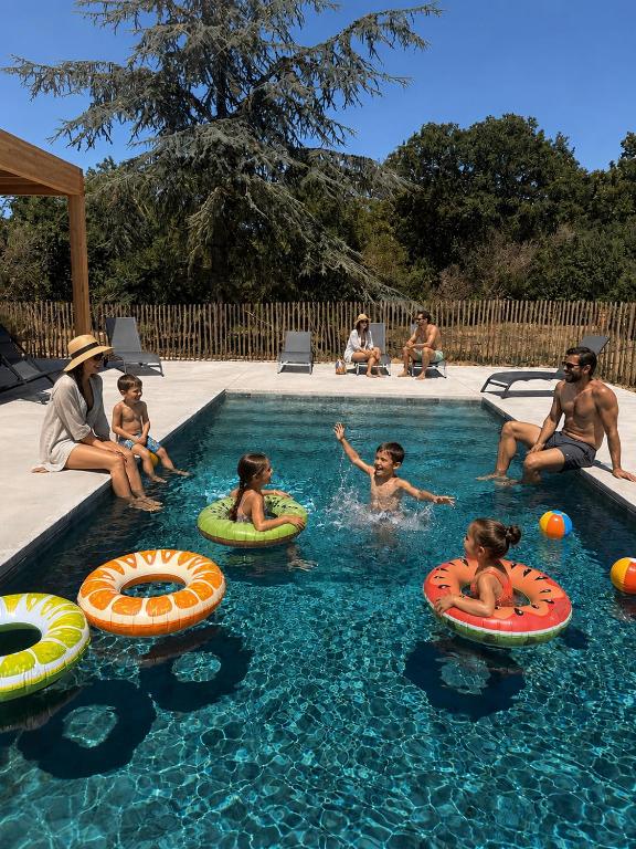 a group of people playing in a swimming pool at Hôtel & Events LE PATIO OCCITAN Toulouse Ouest - Cugnaux in Cugnaux